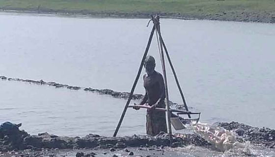 কিশোরগঞ্জের হাওরে কৃষকরা আদিকালের কুন দিয়ে জমিতে পানি